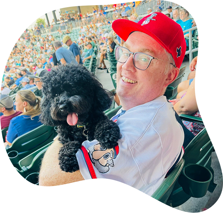 Dr Tennison At Baseball Game Holding His Dog And Smiling