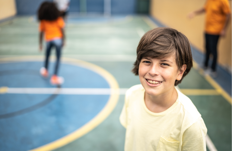 Kid smiling for a picture on the court