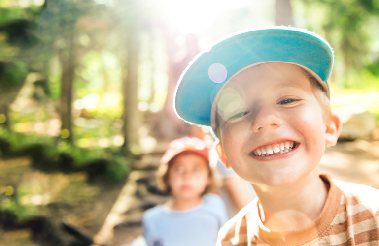 two children smiling in a forest