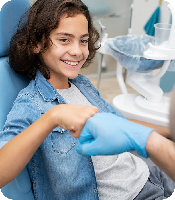 Child bumping fists with doctor and smiling after treatment