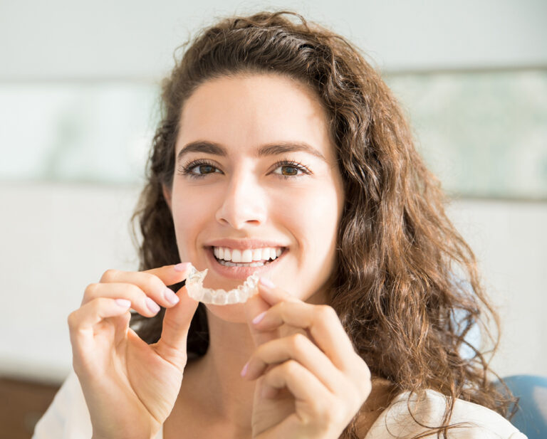 Woman Inserting Clear Smiling Retainer